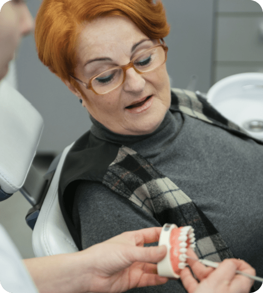A woman with a denturist looking at her same day dentures.