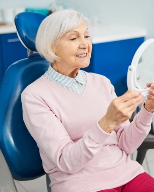 denture patient happy looking at mirror