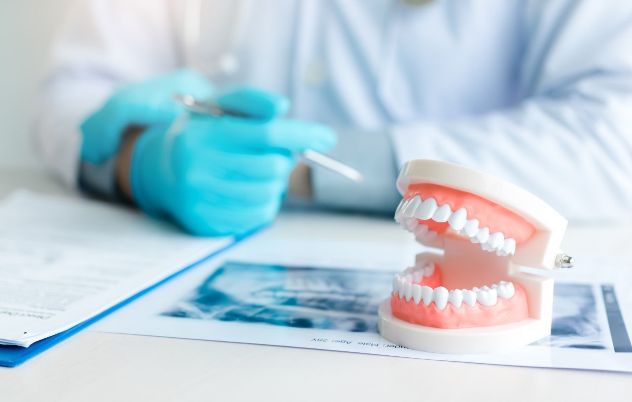 Close up dentures with dentist working on table in clinic