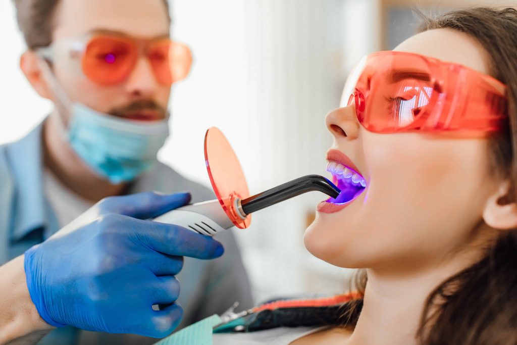 Patient receiving professional in-office teeth whitening treatment at a dental clinic