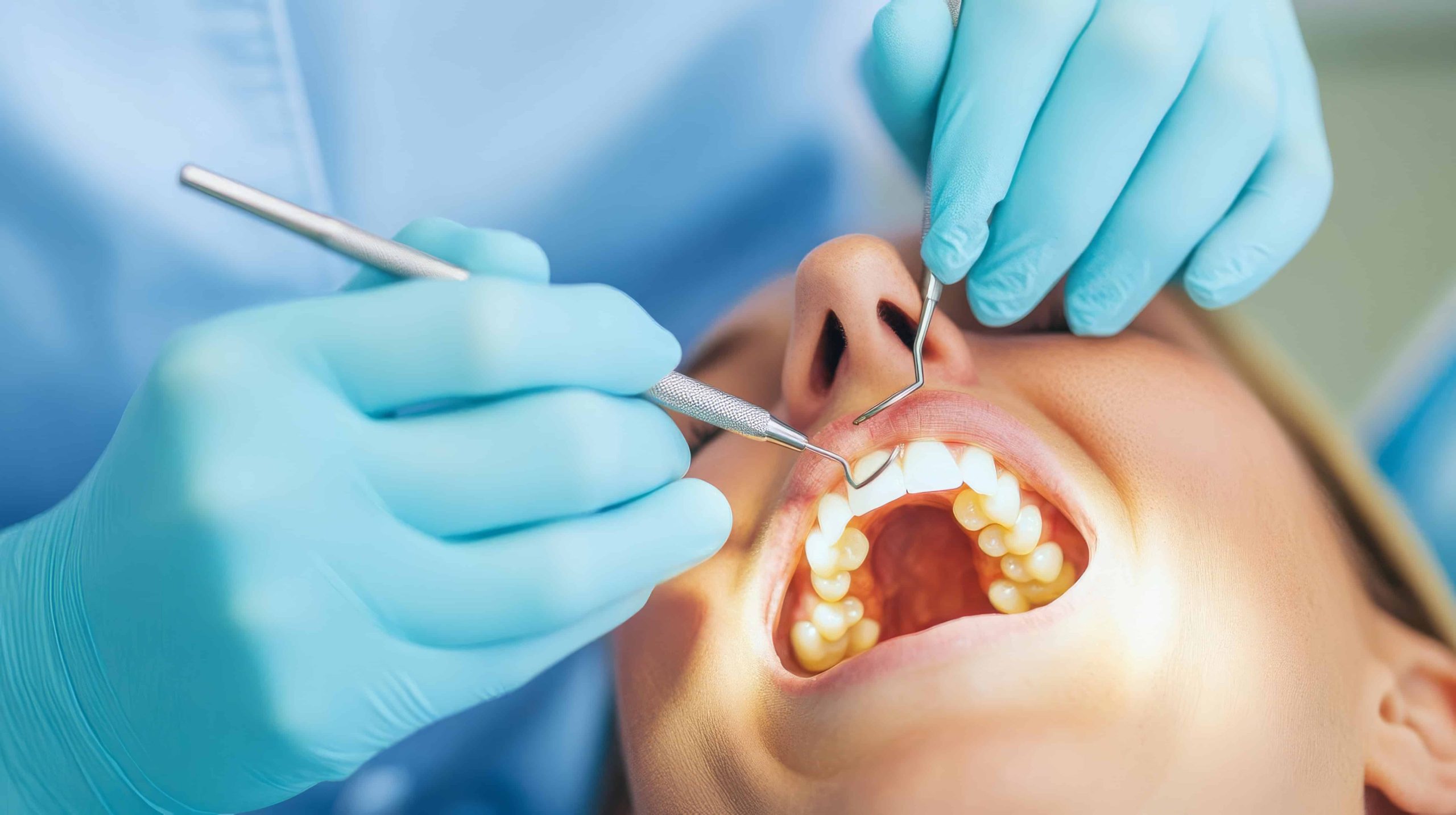 Denturist examining a patient's gums and teeth during a denture fit assessment